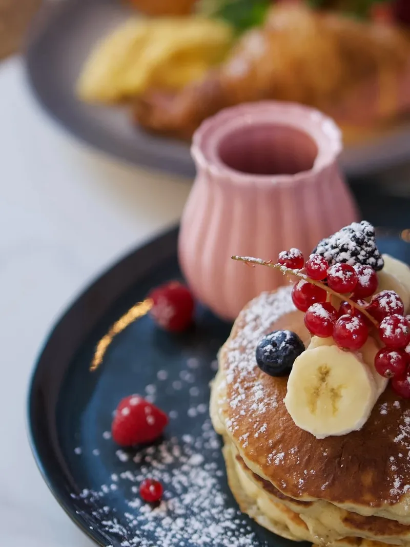 Café Rosewood Nice – table de brunch dressée avec fleurs fraîches et plats du matin